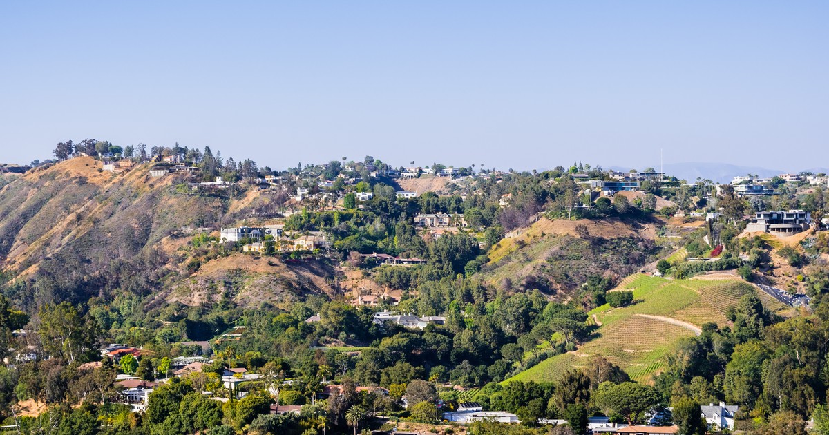 Aerial view of hillside homes nestled among oak-covered canyon slopes in a Southern California neighborhood