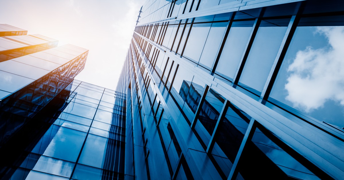 Modern glass office building exterior against a blue sky